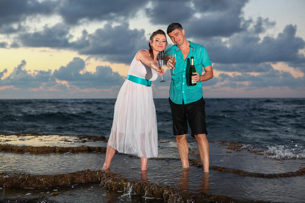 חתן וכלה מוזגים שמפניה בחוף הים - trash the dress לדוגמה 2